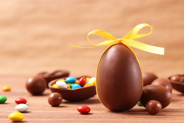 Великодня композиція з шоколадними яйцями та шоколадним кроликом на дерев'яному фоні, місце для тексту
  - Фото, зображення