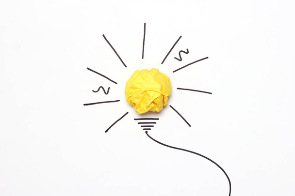koncepcja "pomysł", to nowy pomysł. Malowane żarówki z piłką zmięty papier żółty. - Zdjęcie, obraz