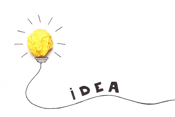 kreatív koncepció "eszme", egy új ötlet. Sárga Összegyűrt papír labdát festett izzó. - Fotó, kép