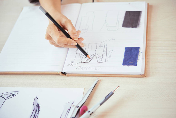 Plon ręka projektanta mody rysowania szkiców stylowe ubrania w pobliżu próbek tkaniny w otwieramy notatnikiem - Zdjęcie, obraz