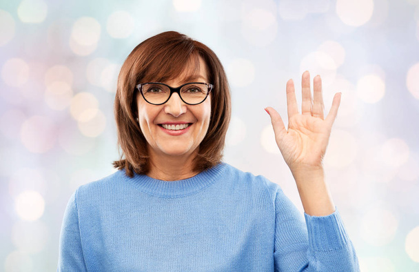 portrait of senior woman in glasses waving hand - Zdjęcie, obraz