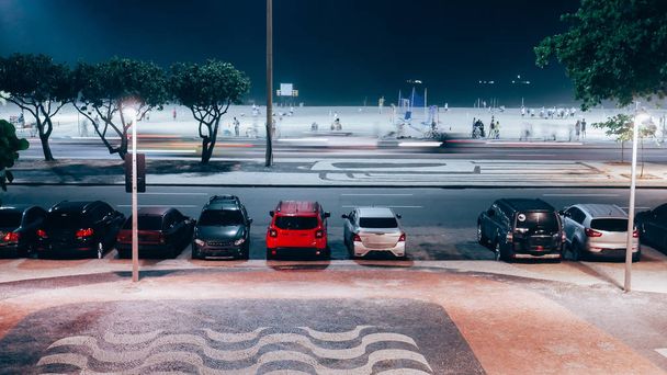 Lunga esposizione di Avenida Atlantica e trafficata spiaggia di Copacabana di notte con carioca e turisti che praticano attività sportive
 - Foto, immagini