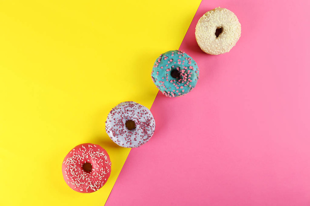 Minimal composition in vibrant colors with bright glaze donuts. - Фото, зображення