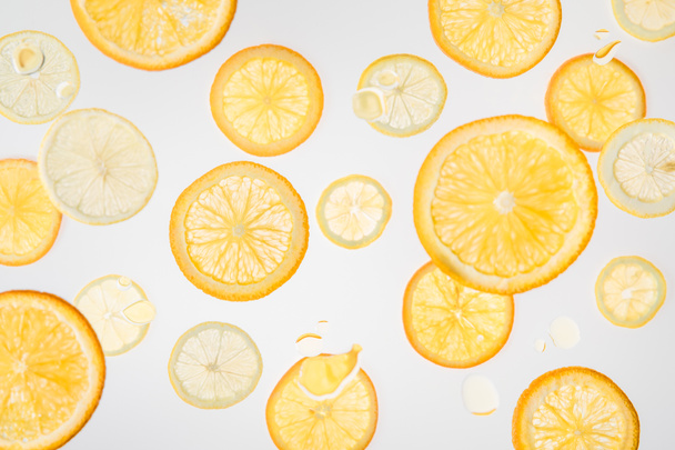světlé čerstvé pomeranče a plátky citronu na šedém pozadí - Fotografie, Obrázek