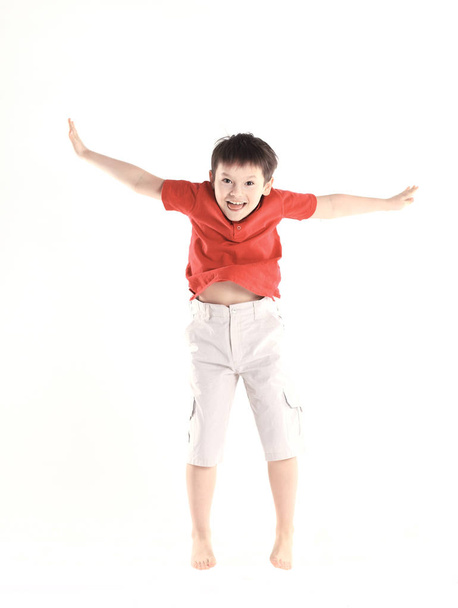 pequeño niño realiza un ejercicio de salto.aislado en blanco
 - Foto, Imagen