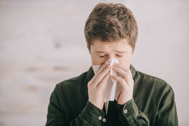hombre que tiene alergia y estornudos en el tejido en casa
  - Foto, Imagen