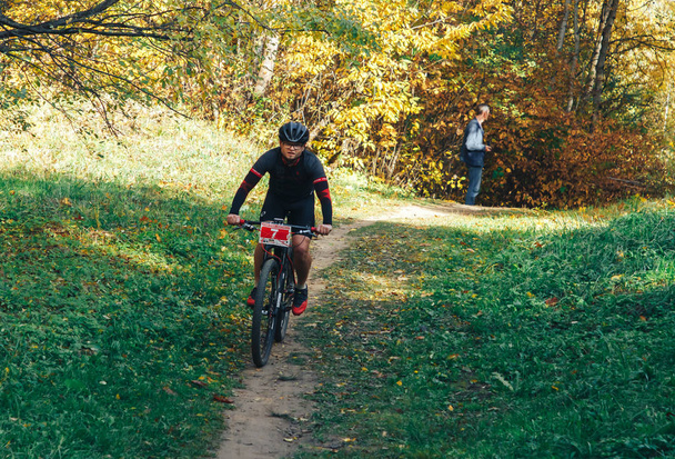 October 14, 2018, Minsk, Belarus.2018 Olympic Cross Country Cup XCO in Medvezhino A man cycling along a forest trail - 写真・画像