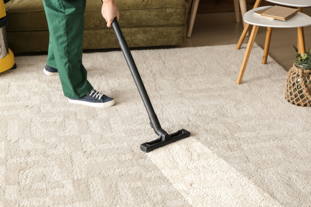 Worker cleaning carpet with hoover - Photo, Image