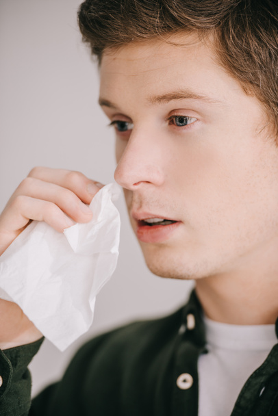 close up of sick handsome man having allergy and holding tissue  - Photo, Image