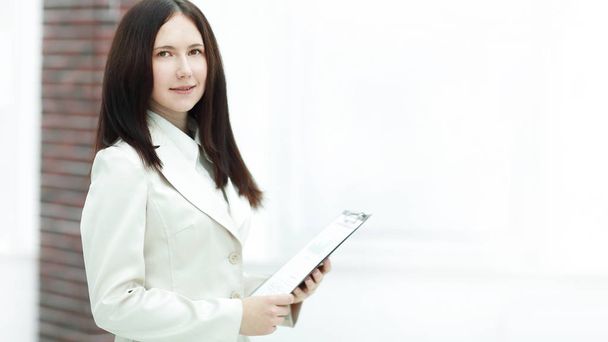 elegant business woman with clipboard on light office background - Foto, Imagem