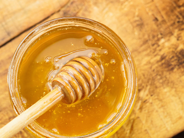 honey with wooden mixer top view - Photo, Image