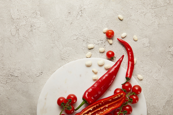 Top view of chili peppers, cherry tomatoes and beans on textured surface - Foto, Imagem
