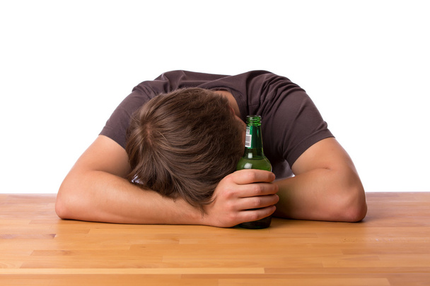 Homme dormant sur une table avec de la bière
 - Photo, image