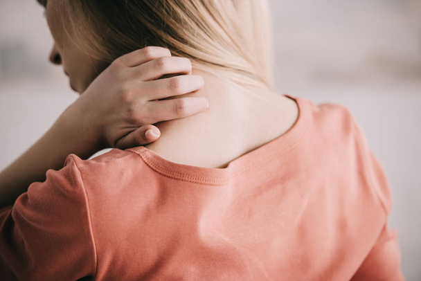 Вид сзади женщины, царапающей шею во время аллергии
  - Фото, изображение