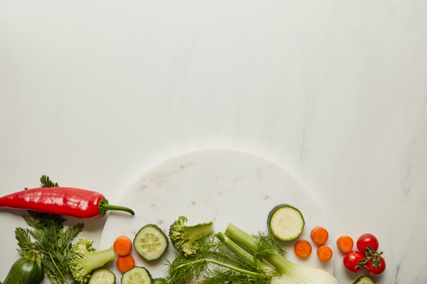Top näkymä koko ja leikkaa vihanneksia valkoisella pinnalla
 - Valokuva, kuva