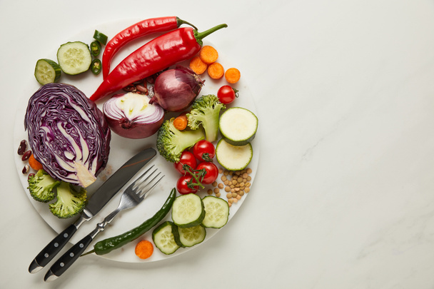 Vista superior de cubiertos y verduras frescas en la superficie blanca
 - Foto, Imagen