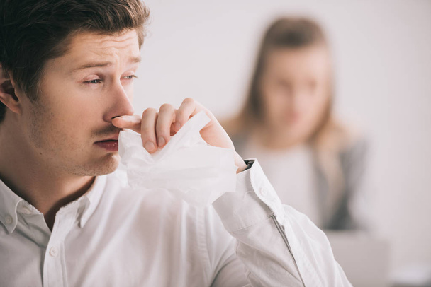 selective focus of man having allergy in office near colleague   - Photo, Image