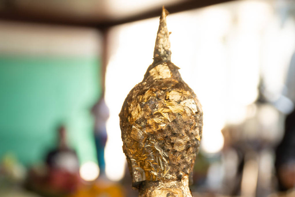Gold leaf placed on a statue of Buddha by worshipers at the Wat Arun temple in Bangkok, Thailand. - Photo, Image