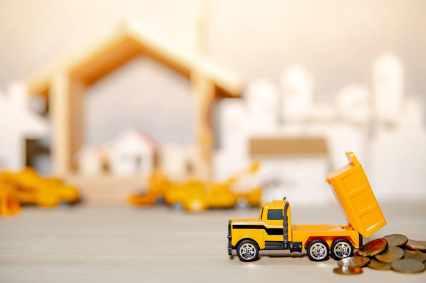 Модель вантажівки проливає золоті монети на столі
 - Фото, зображення
