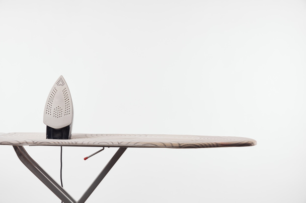 Ironing board with dark legs and iron isolated on grey - Photo, image