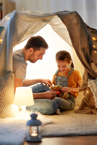 happy family playing with toy in kids tent at home - Foto, afbeelding