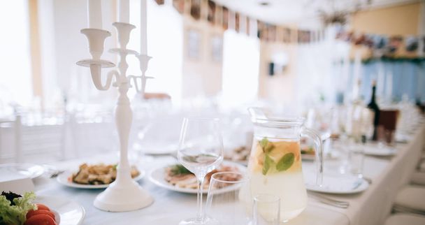 елегантна обстановка весільного столу з їжею, напоєм та свічками
 - Фото, зображення