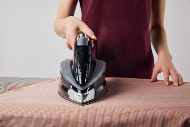 Partial view of young woman ironing clothes with iron - Fotoğraf, Görsel