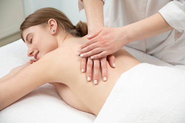 Beautiful young woman receiving massage in spa salon - Foto, imagen