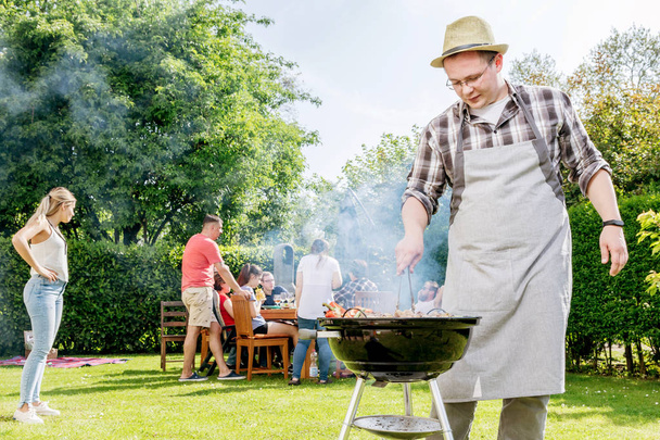 Group of friends having outdoor garden barbecue  - Photo, Image