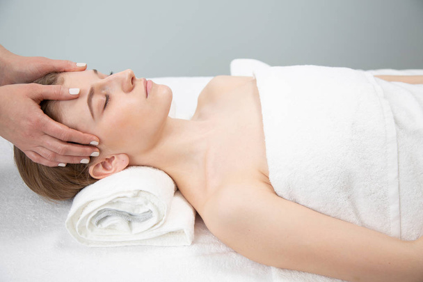 Relaxed woman receiving neck massage in wellness center - Photo, Image