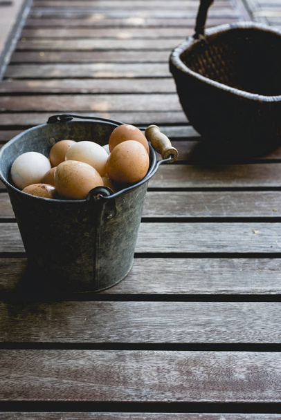 Ведро с куриными яйцами и плетеной корзиной
. - Фото, изображение