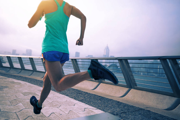 Healthy lifestyle woman runner running on foggy city morning - Фото, зображення