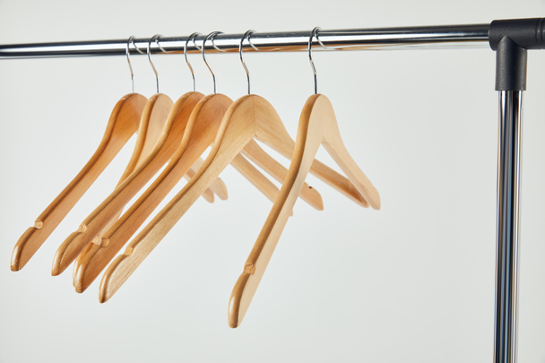 Steel straight rack with wooden hangers isolated on grey - Photo, Image