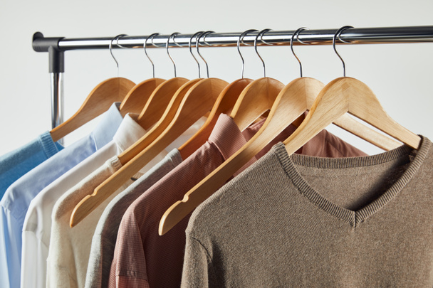 Straight rack, wooden hangers and male clothes isolated on grey - Photo, Image