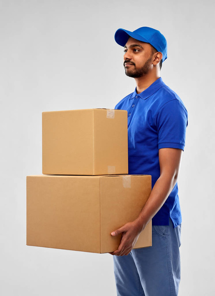 indian delivery man with parcel boxes in blue - Photo, Image