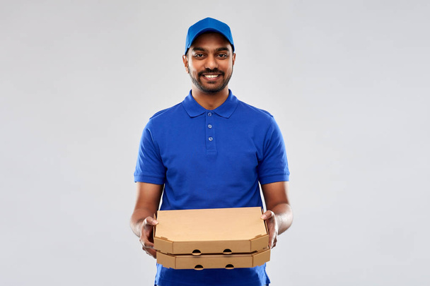 happy indian delivery man with pizza boxes in blue - Foto, Imagen