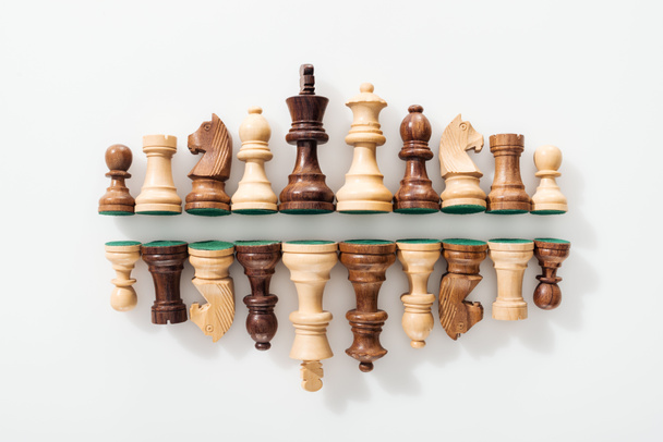 Ansicht der Reihen aus hölzernen Schachfiguren auf weißem Hintergrund  - Foto, Bild