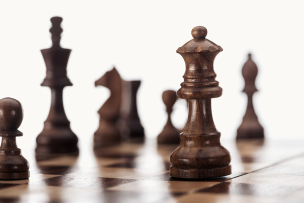 selective focus of wooden chessboard with dark brown chess figures isolated on white - Φωτογραφία, εικόνα