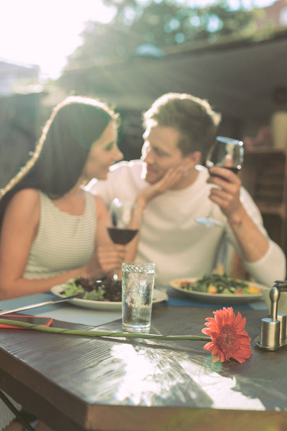 Dark-haired pleasant girl caressing her handsome boyfriend while holding wine - Foto, immagini