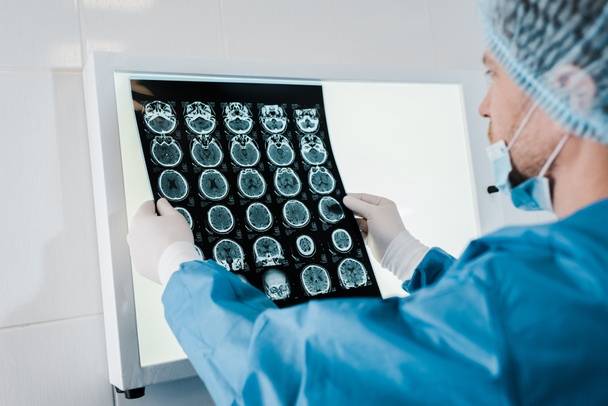 foyer sélectif du médecin en bonnet médical et gants en latex tenant des rayons X en clinique
  - Photo, image