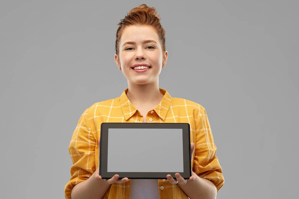red haired teenage girl showing tablet computer - Foto, afbeelding