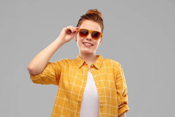 smiling red haired teenage girl in sunglasses - Foto, afbeelding