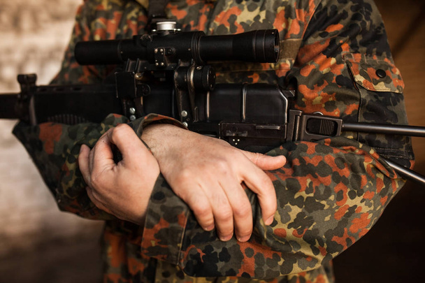A soldier is holding a gun in his hands - Foto, afbeelding