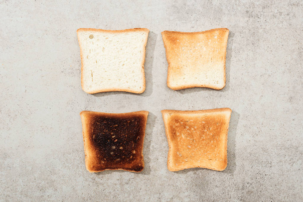 Vista superior de torradas de pão na superfície texturizada cinza
 - Foto, Imagem