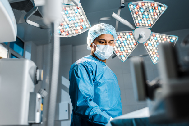 selective focus of doctor in medical mask and uniform in operating room  - Photo, Image
