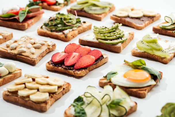Toasts with cut fruits, fried egg and peanuts on white - Fotografie, Obrázek