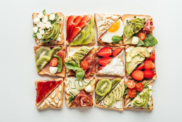 top view of toasts with fresh fruits and vegetables isolated on white - Foto, afbeelding