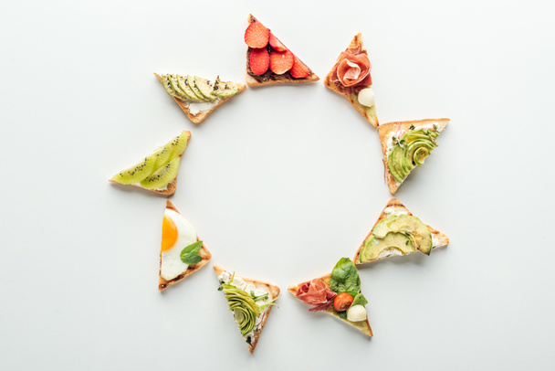 верхний вид тостов с фруктами и овощами, расположенных в рамке изолированы на белом с копировальным местом
 - Фото, изображение
