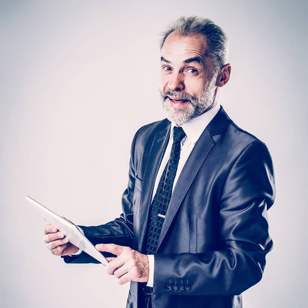 successful businessman with digital tablet on light background - 写真・画像