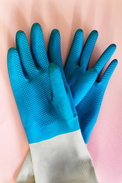 Gloves blue for cleaning and protection of hands, on pink background. garden work, work with the ground, aggressive cleaning agents, spring cleaning - Фото, изображение